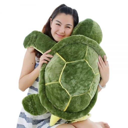 Femme tenant une peluche tortue verte