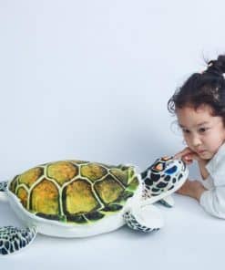 fillette joue avec une peluche tortue de mer